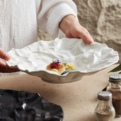 White ceramic serving plate with a wavy, crumpled, or lettuce-leaf rim texture